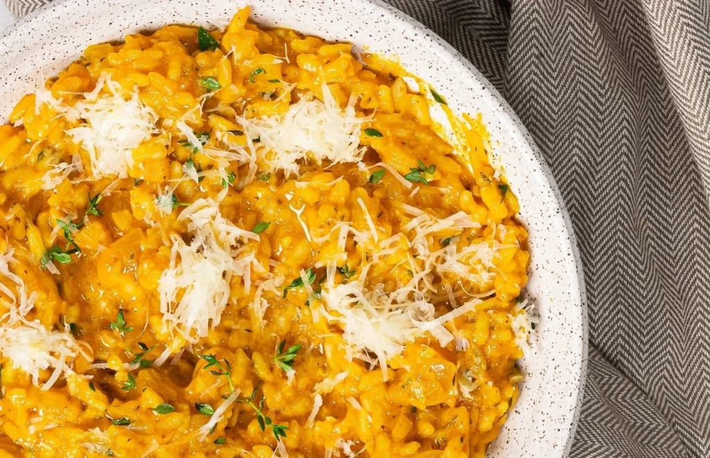 Prato colorido de risoto vegano de abóbora com ervas frescas